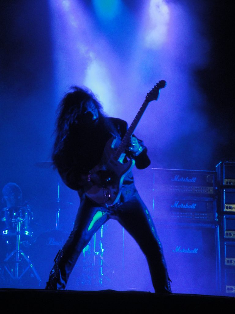 Yngwie Malmsteen shredding in a power stance in front of a Marshall cabinet likely loaded with Celestion G12T 75s!