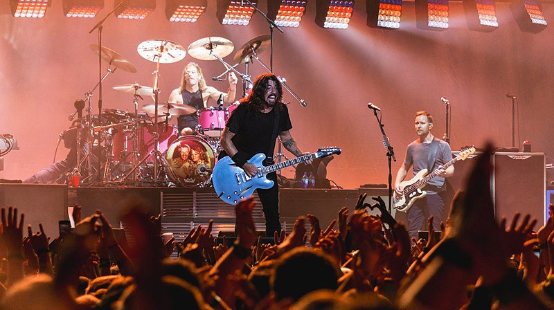 Dave Grohl, Nate Mendel, and Taylor Hawkins from Foo Fighters performing live in front of a crowd